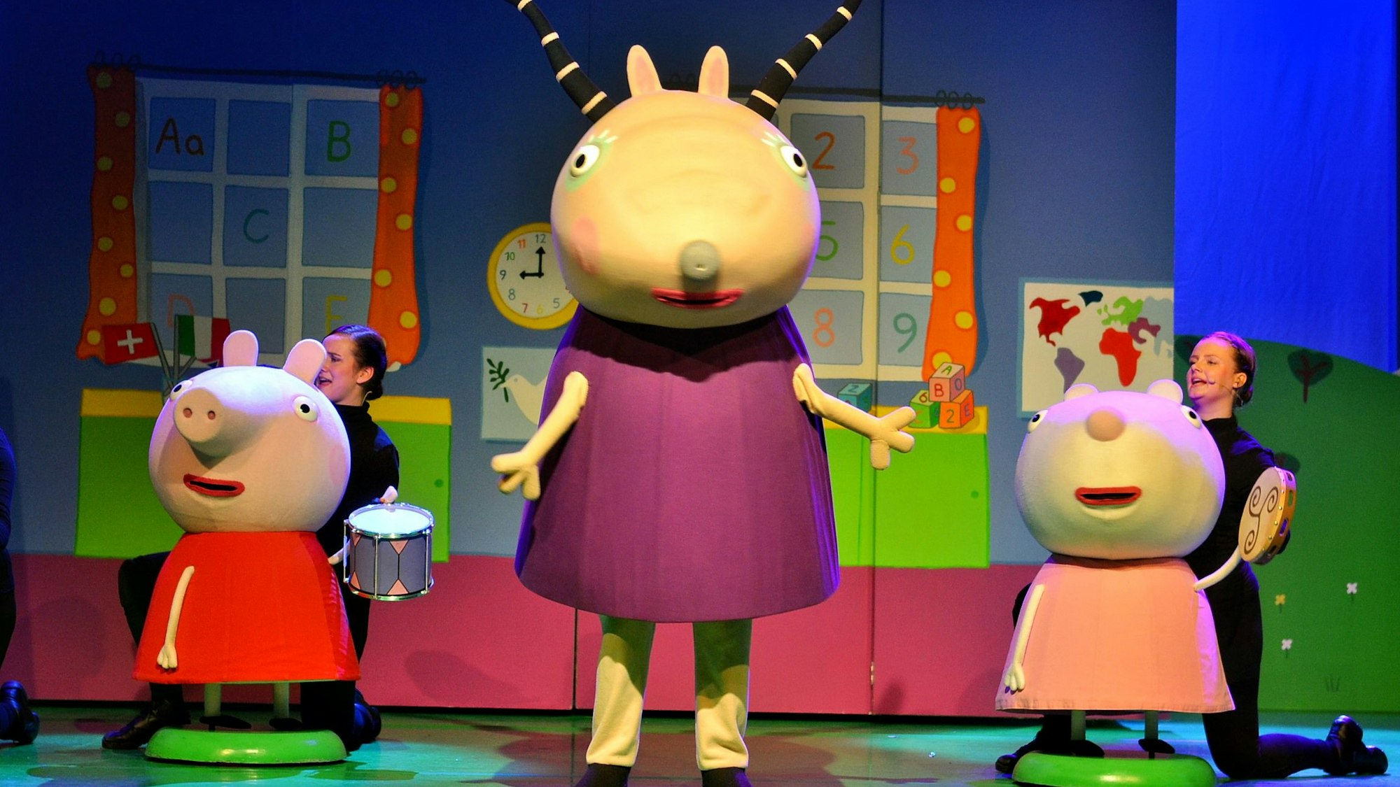 Drei Fantasiefiguren sind auf der Bühne des Theaters in Euskirchen zu sehen. Hinter den beiden kleineren knien in schwarz gekleidete Schauspielerinnen.