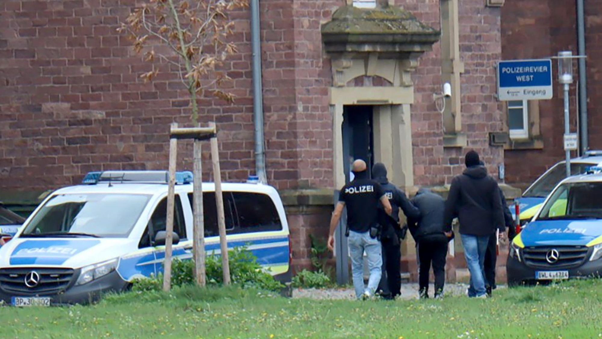 20.10.2024, Baden-Württemberg, Karlsruhe: Polizisten bringen den in Bernau bei Berlin festgenommenen mutmaßlichen IS-Unterstützer, der einen Anschlag mit Schusswaffen auf die israelische Botschaft in Berlin geplant haben soll, zur Haftvorführung. Foto: René Priebe/dpa +++ dpa-Bildfunk +++