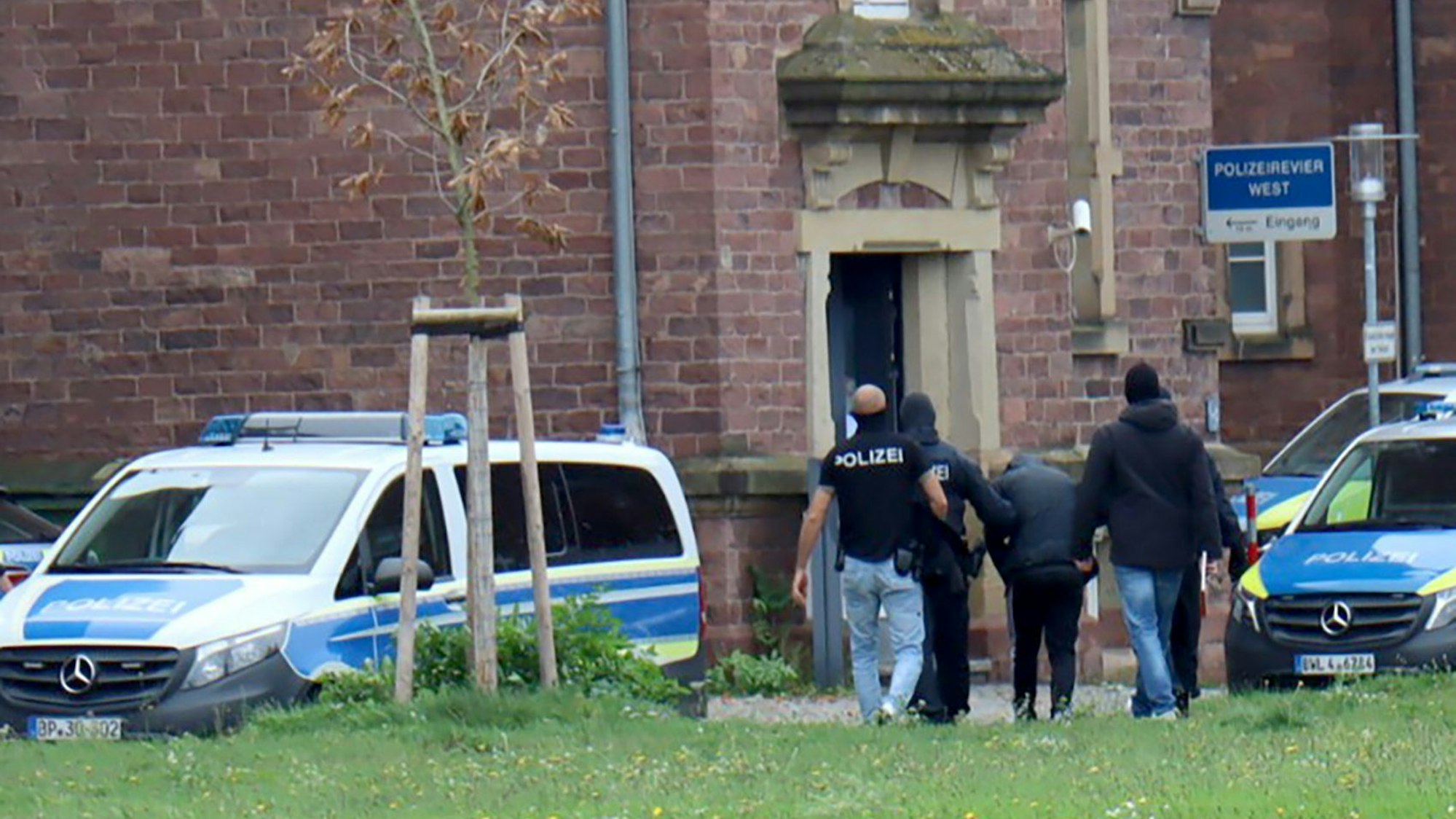 20.10.2024, Baden-Württemberg, Karlsruhe: Polizisten bringen den in Bernau bei Berlin festgenommenen mutmaßlichen IS-Unterstützer, der einen Anschlag mit Schusswaffen auf die israelische Botschaft in Berlin geplant haben soll, zur Haftvorführung. Foto: René Priebe/dpa +++ dpa-Bildfunk +++