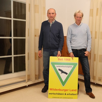 Horst Braun (links) und Christoph Gehrke von der Bürgerinitiative Wildburger Land informierten über den Stand der Dinge beim Bau von Windkraftanlagen in der Ortschaft Steeg. Unser Foto zeigt die beiden Männer mit einem Schild aus dem Landschaftsschutz.