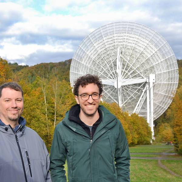 Die Forscher Benjamin Winkel und Marlon Bause (v.l.) stehen vor dem Radioteleskop in Effelsberg.