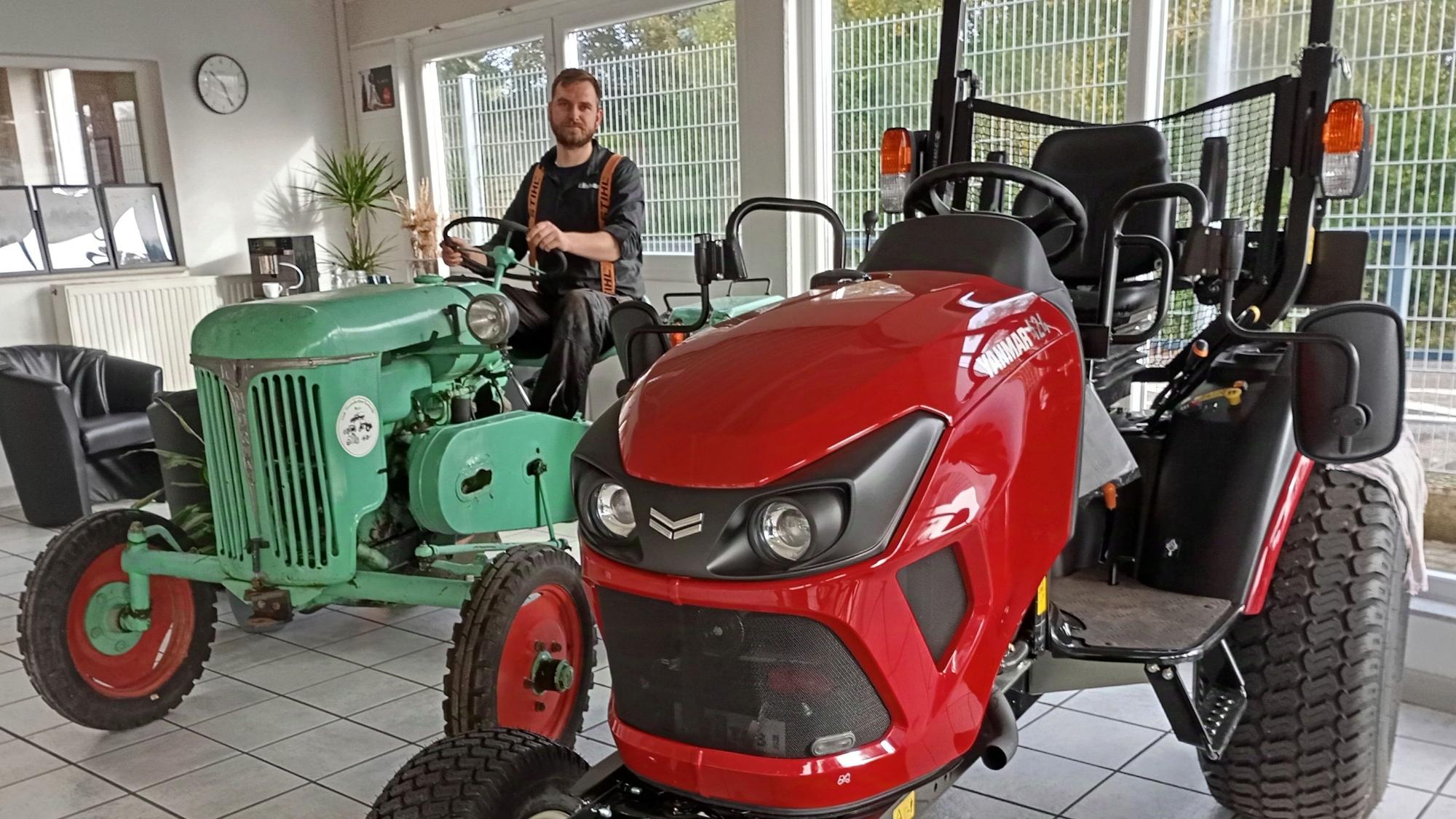 Ein Mann sitzt auf einem Traktor, er lächelt in die Kamera.
