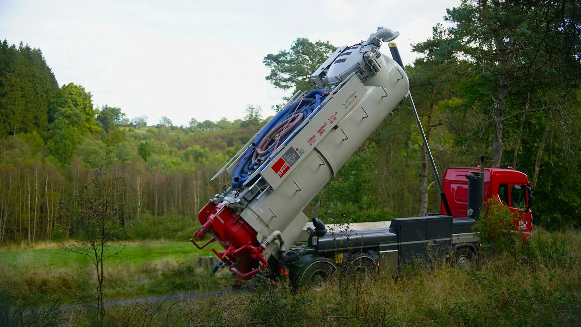 Ein LKW-Saugbagger steht mit gekipptem Tank auf einem Wanderweg im Fuhrtsbachtal.