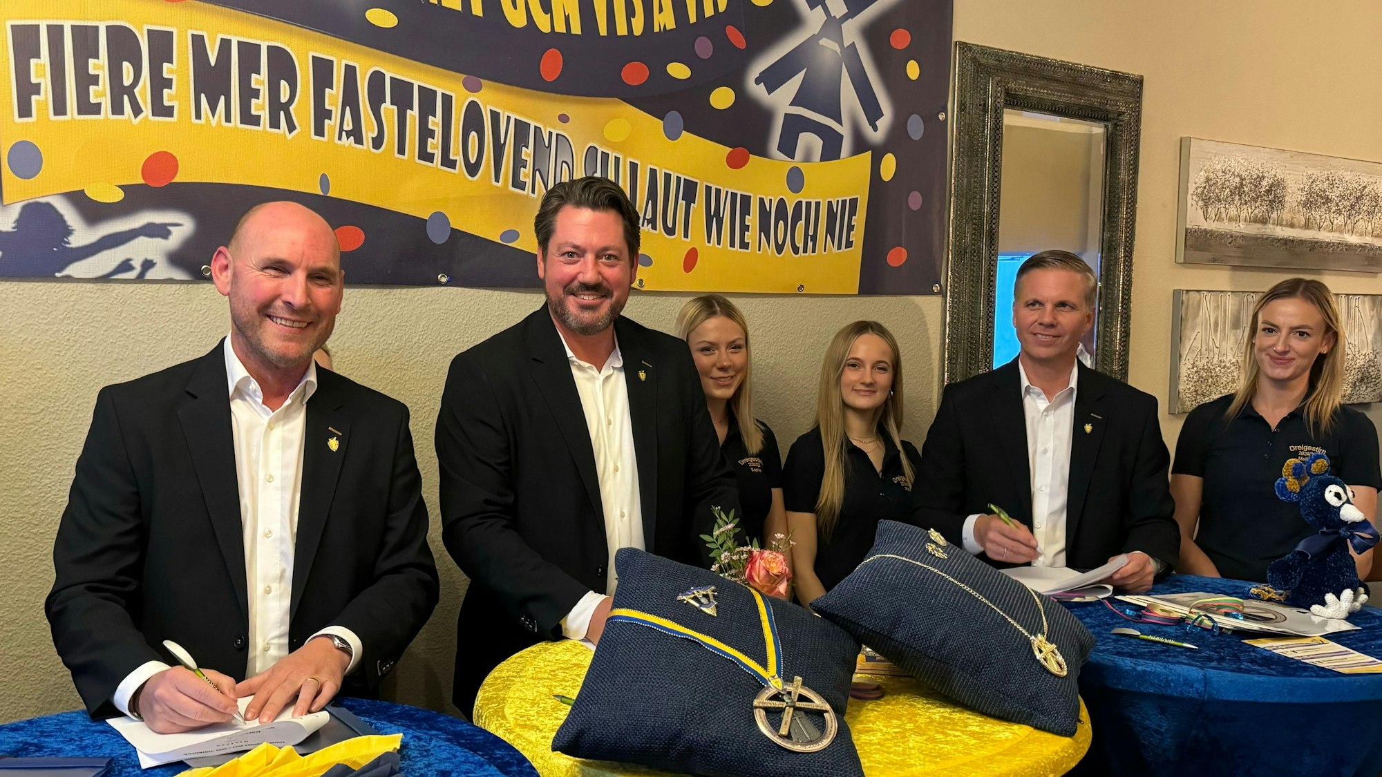 Männer und Frauen stehen an Stehtischen.