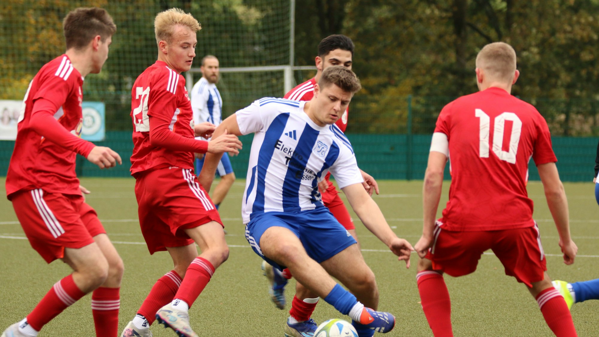 Ein ballführender Fußballer wird von gleich vier Gegenspielern umringt.