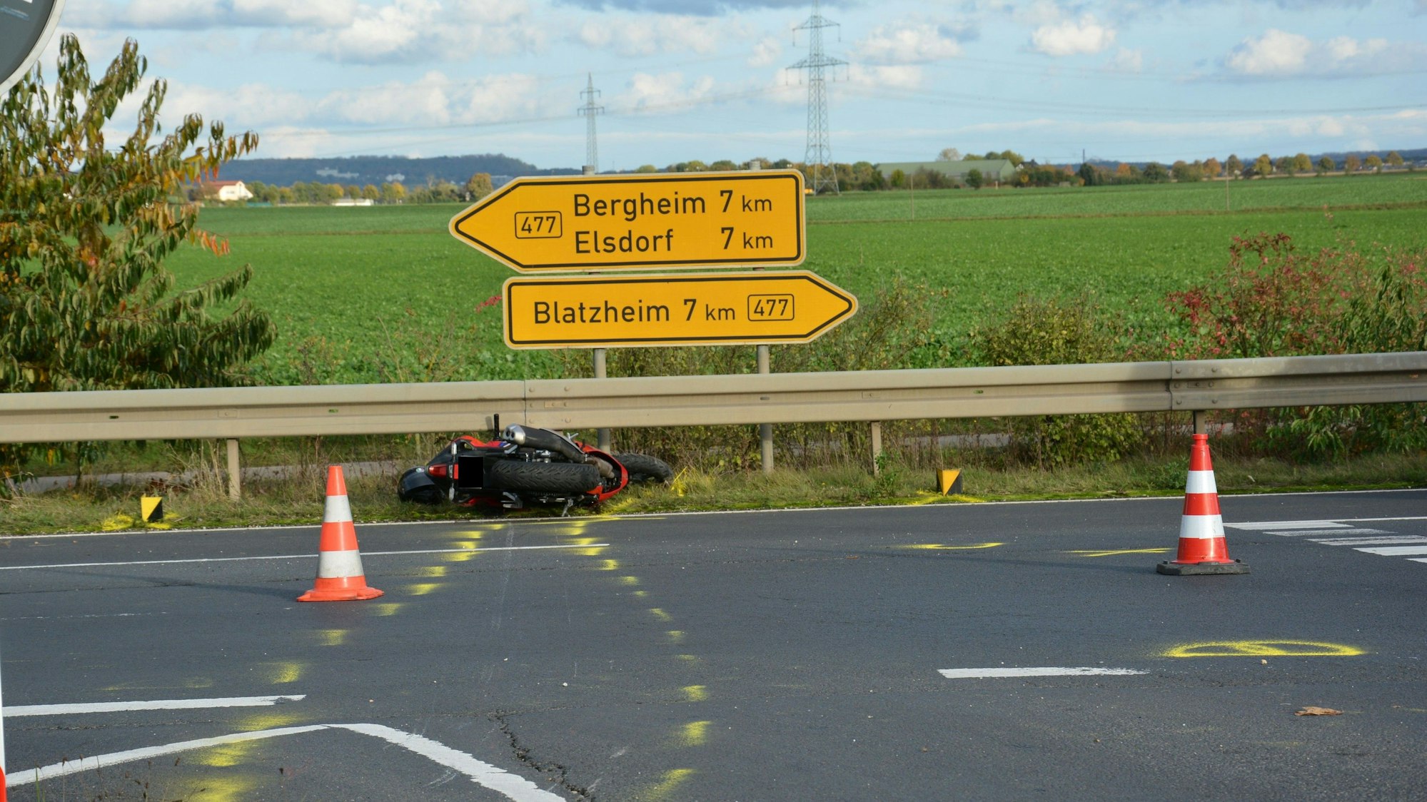 Das verunfallte Motorrad liegt im Seitenstreifen vor der Leitplanke und Verkehrsschildern.