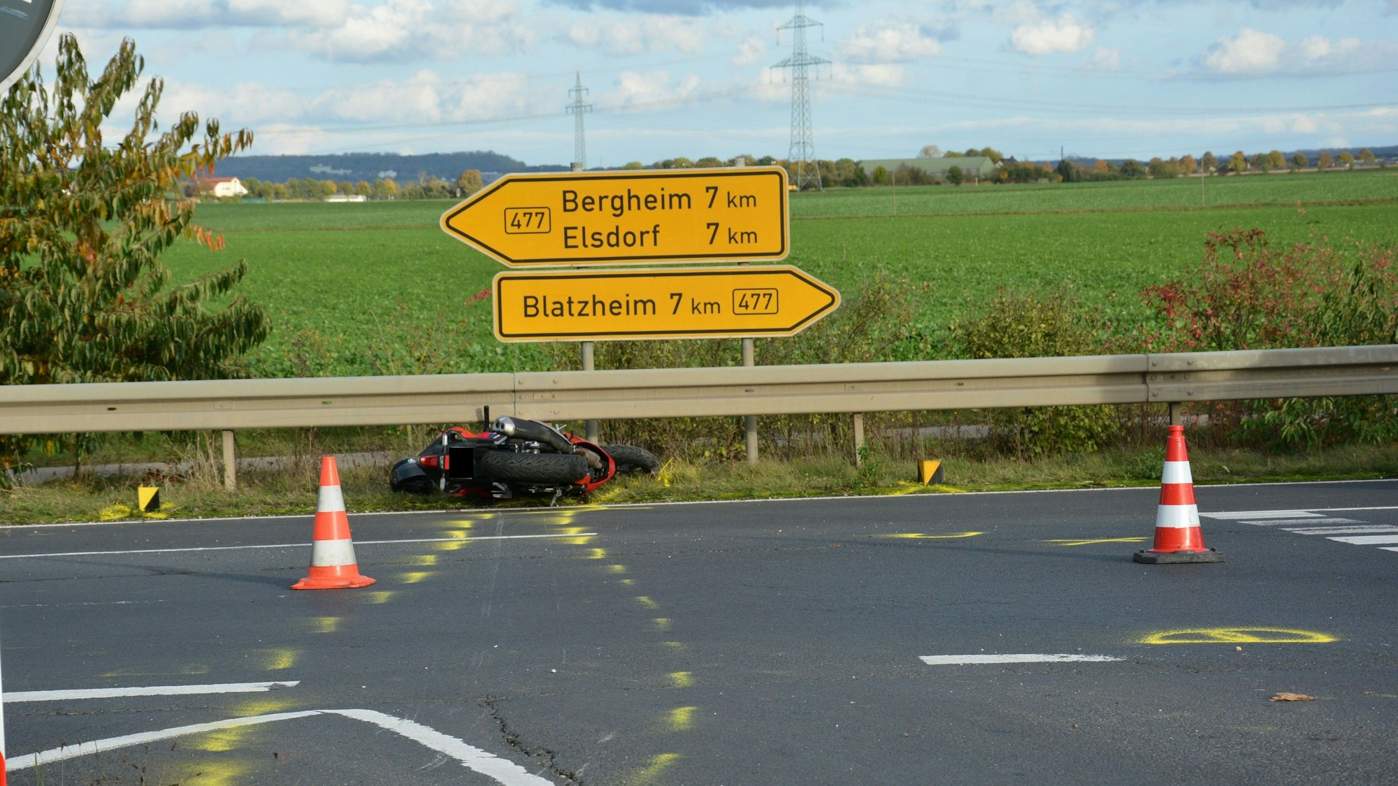 Das verunfallte Motorrad liegt im Seitenstreifen vor der Leitplanke und Verkehrsschildern.
