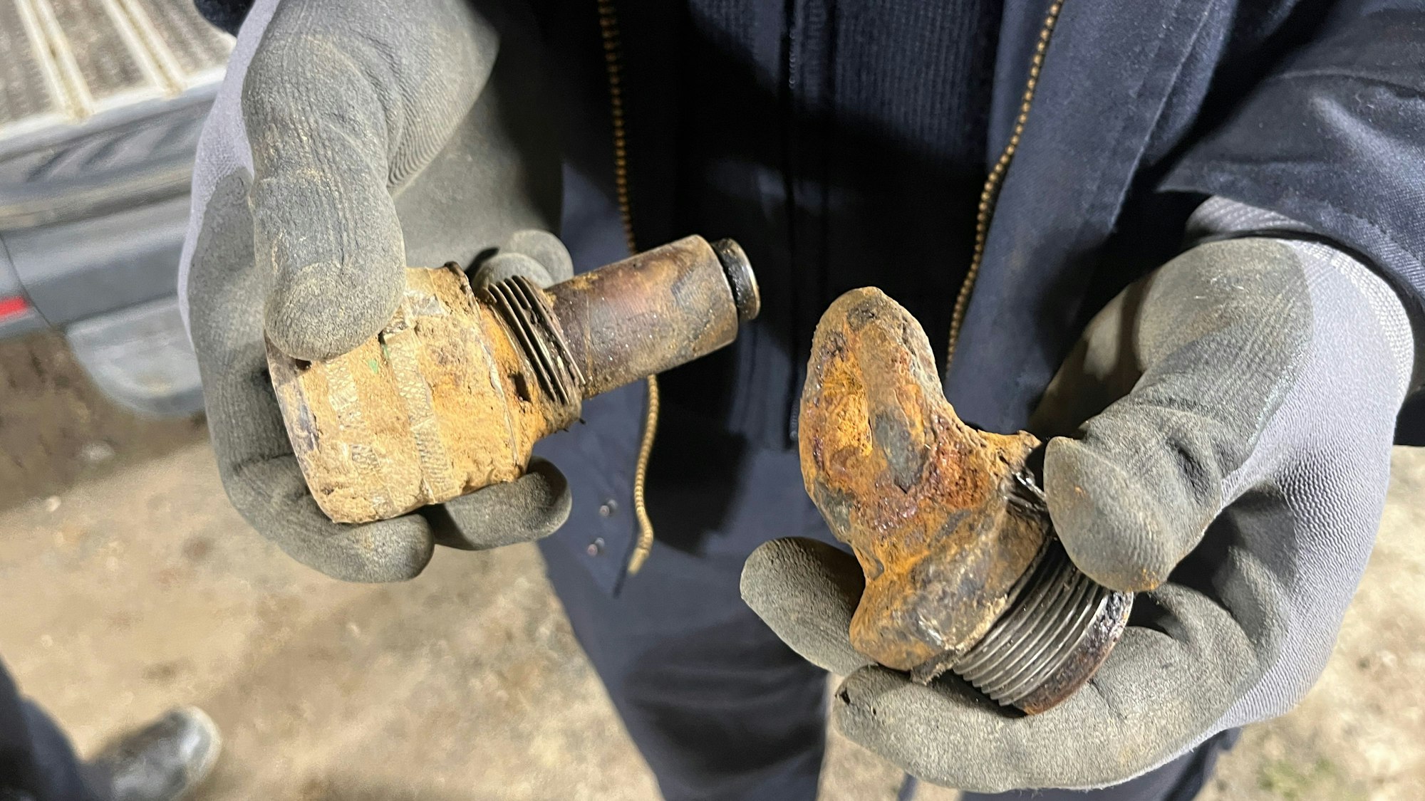 Zwei Hände zeigen den verbogenen Zünder und das Gewinde der Bombe in Troisdorf.