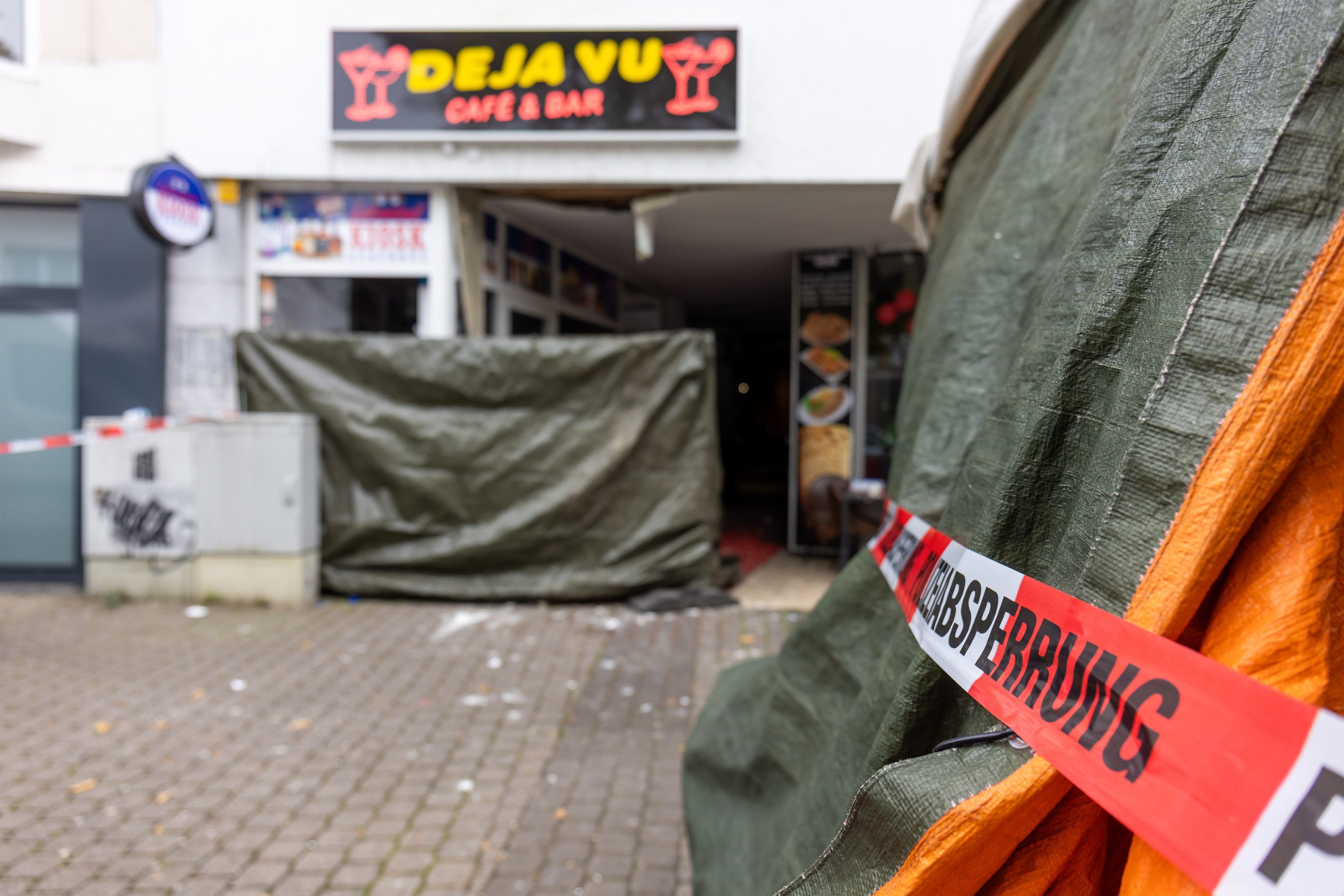 Hessen, Wetzlar: Polizeiabsperrung und Sichtschutz sind vor einem Cafe zu sehen, vor dem in den frühen Morgenstunden ein Sprengsatz explodiert war.