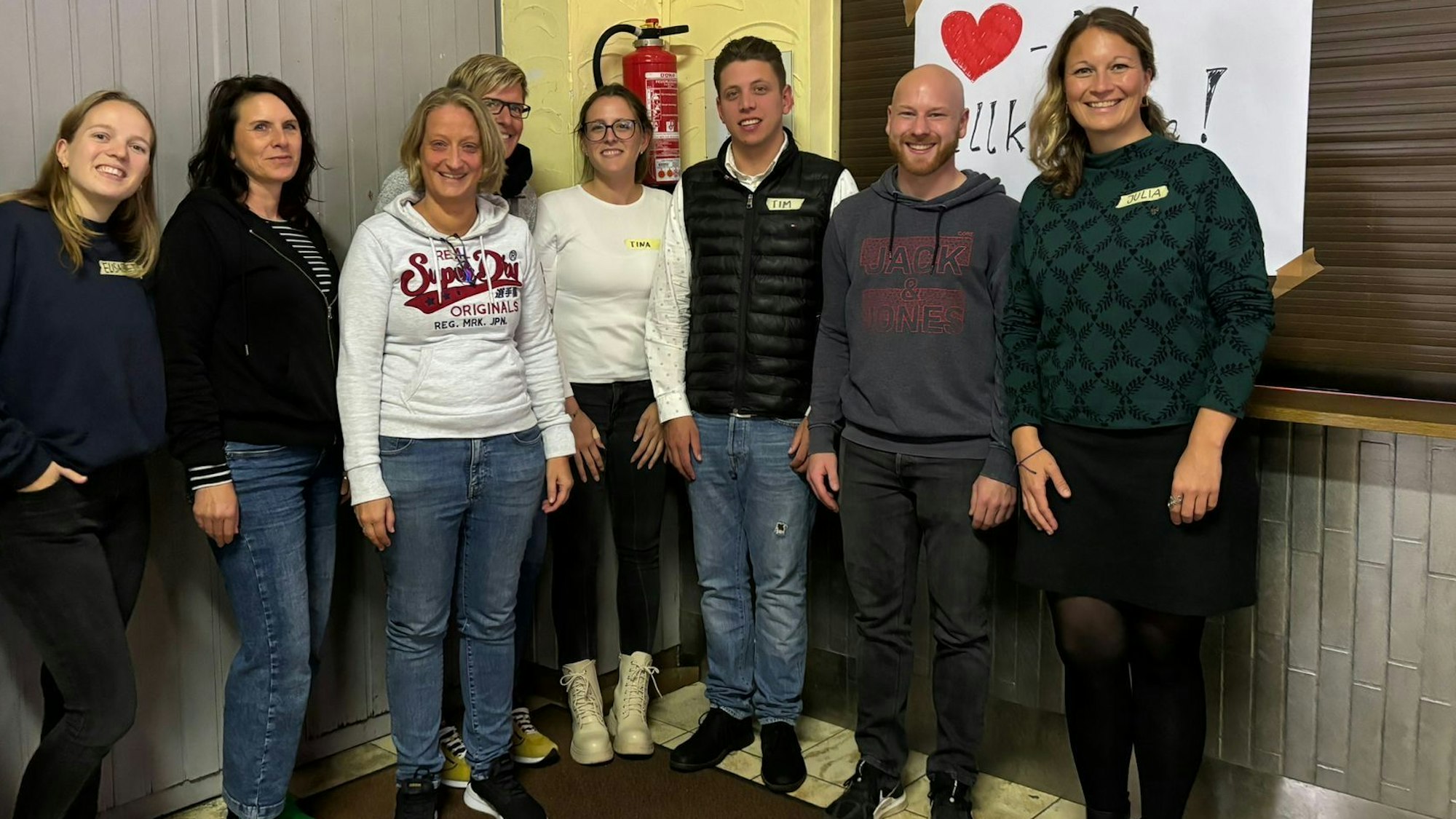 Unter der Leitung von Elisabeth Weißner (links) und Julia Wäger (rechts) von der Projektagentur Oberberg fand in Waldbröl-Schönenbach ein Workshop zur Sanierung des Dorfgemeinschaftshauses statt. Hier posiert die ganze Gruppe vor der Küche des Hauses.