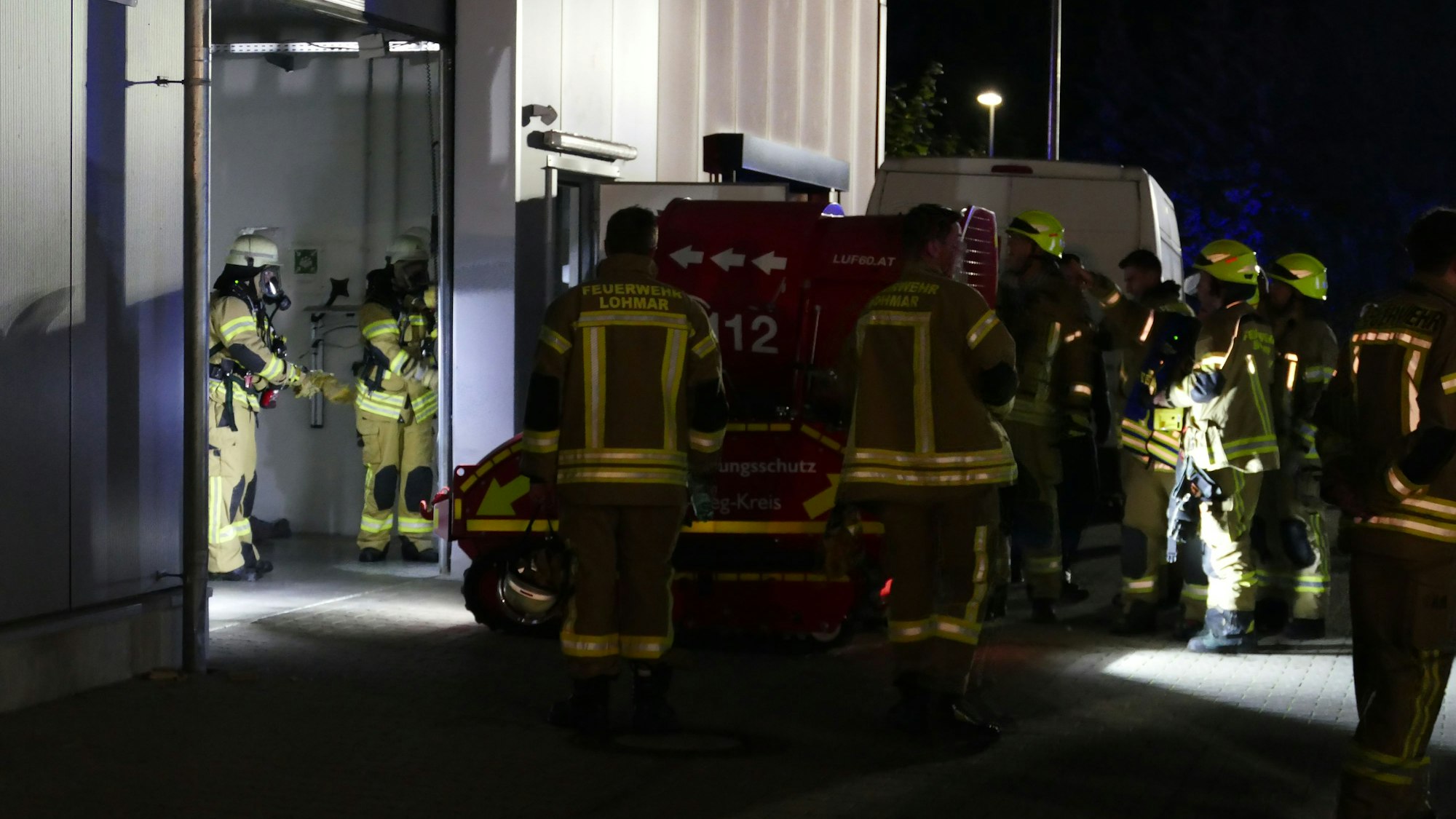 Die Feuerwehrleute fuhren einen großen Ventilator in die Halle.