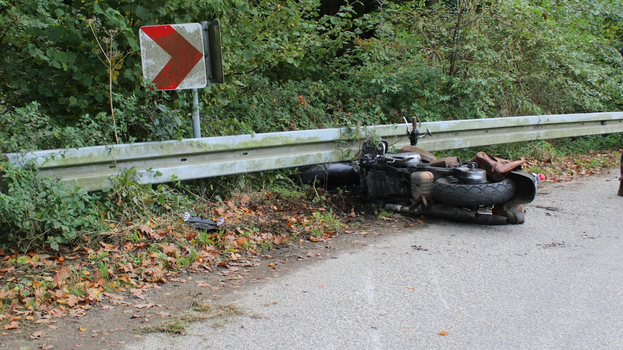 Ein Motorrad ist unter die Leitplanke an einer Landstraße gerutscht.