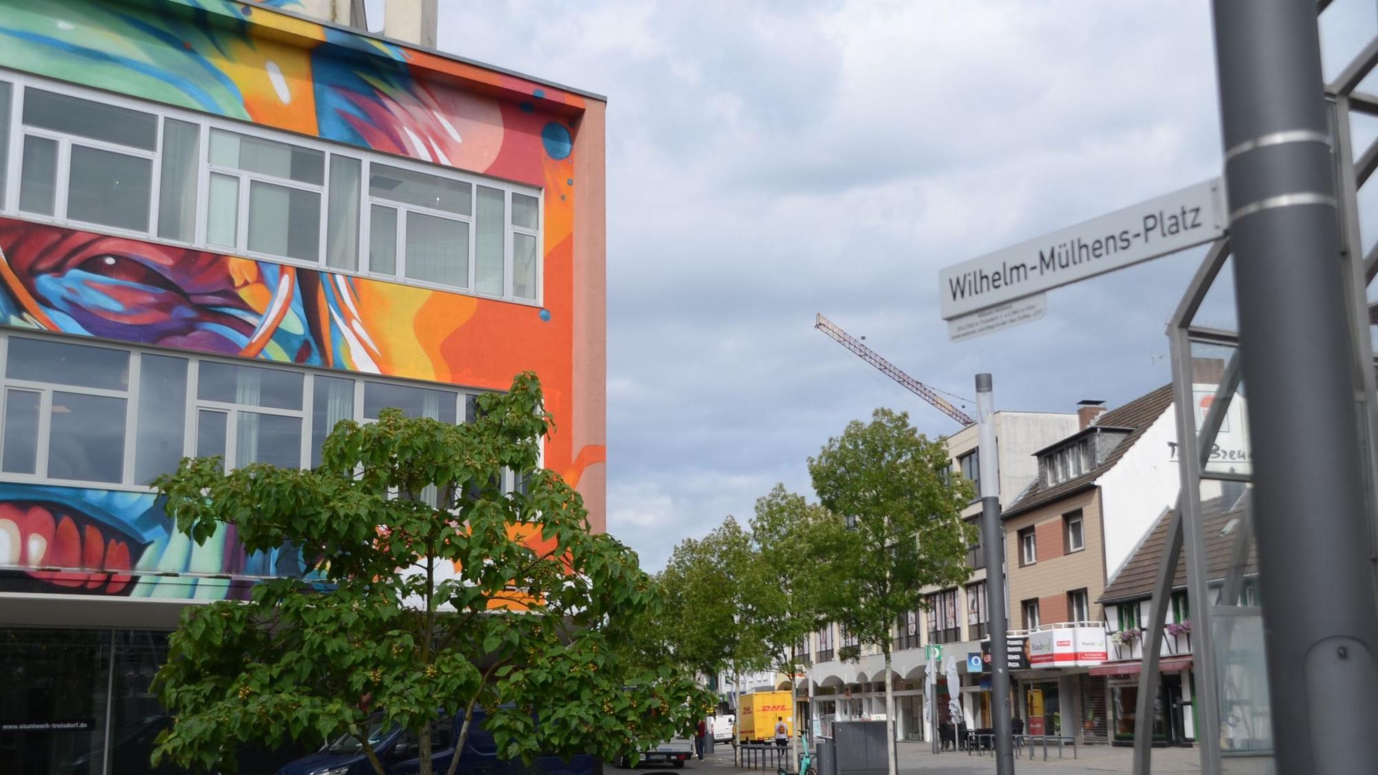Ein bunt bemaltes Kaufhaus an einer Fußgängerzone.