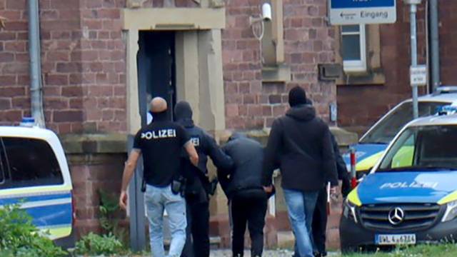 20.10.2024, Baden-Württemberg, Karlsruhe: RECROP - Polizisten bringen den in Bernau bei Berlin festgenommenen mutmaßlichen IS-Unterstützer, der einen Anschlag mit Schusswaffen auf die israelische Botschaft in Berlin geplant haben soll, zur Haftvorführung. Foto: René Priebe/dpa +++ dpa-Bildfunk +++