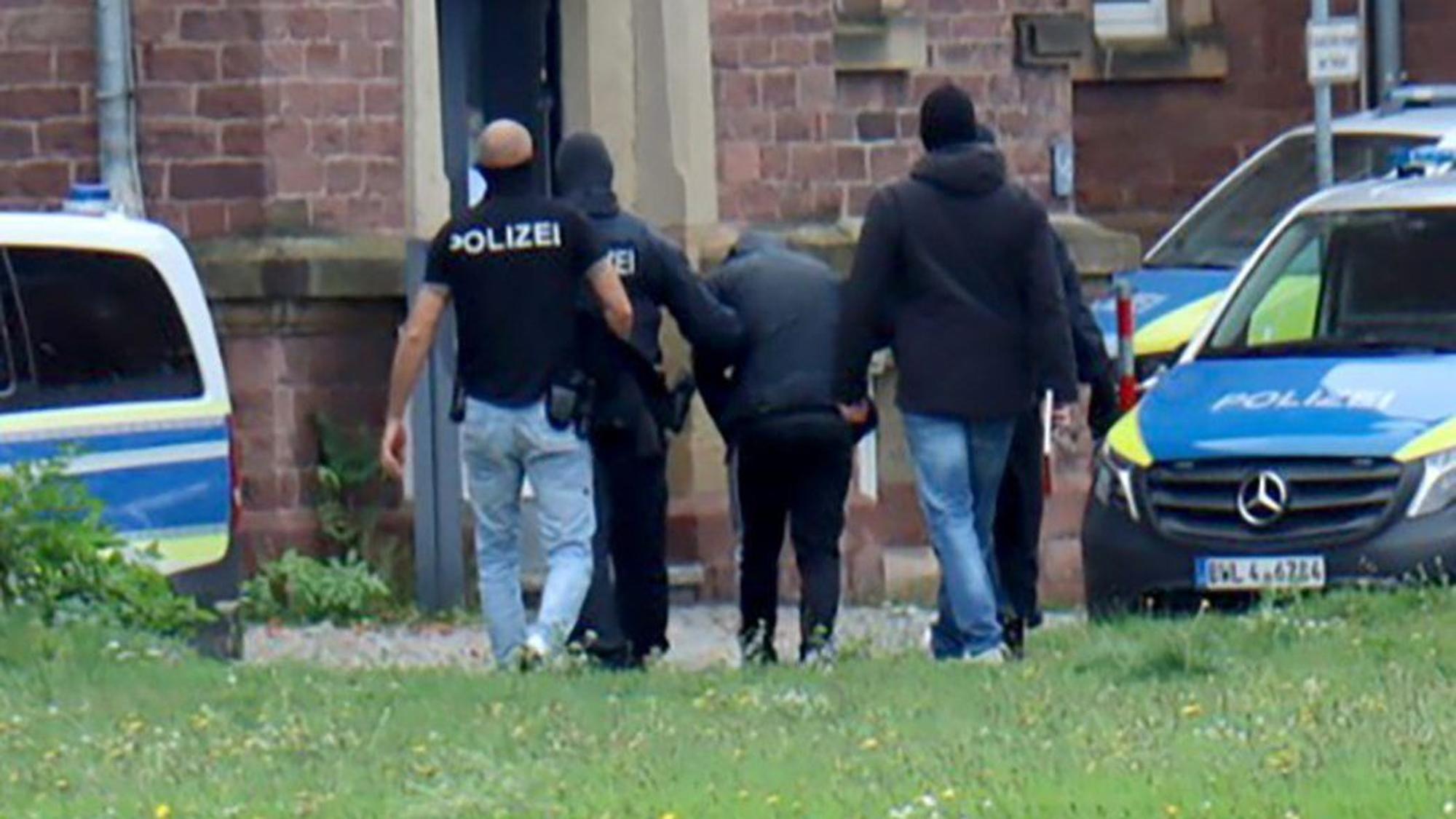 20.10.2024, Baden-Württemberg, Karlsruhe: RECROP - Polizisten bringen den in Bernau bei Berlin festgenommenen mutmaßlichen IS-Unterstützer, der einen Anschlag mit Schusswaffen auf die israelische Botschaft in Berlin geplant haben soll, zur Haftvorführung. Foto: René Priebe/dpa +++ dpa-Bildfunk +++
