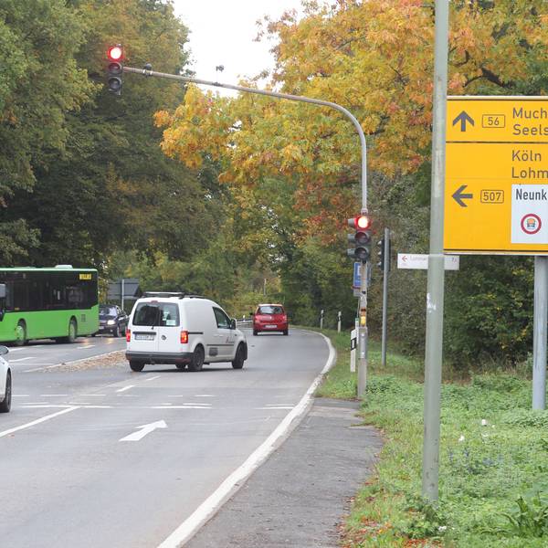 Straße mit Autoverkehr und Hinweisschild