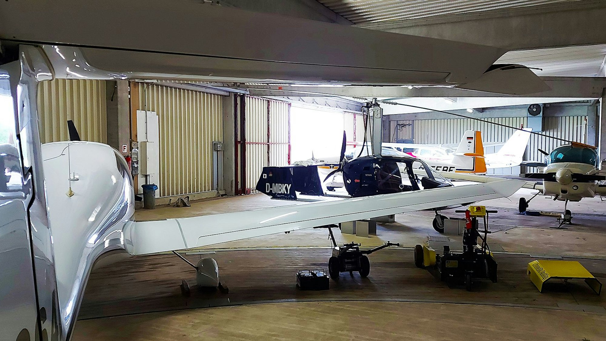 In einem Hangar stehen mehrere kleine Flugzeuge.