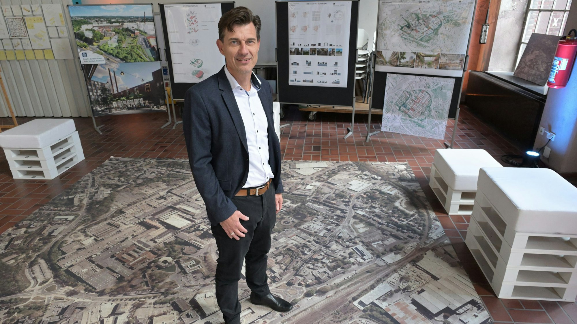 Oliver Brügge steht auf einer Luftaufnahme von Zanders.