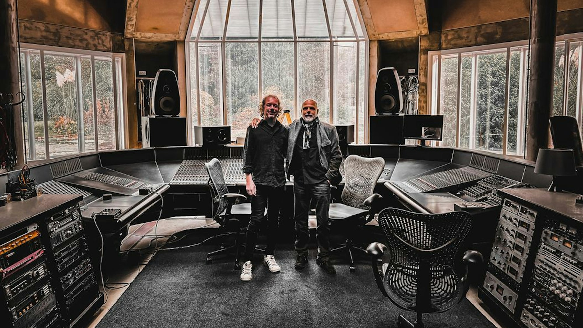 Zwei Männer stehen in einem Tonstudio.