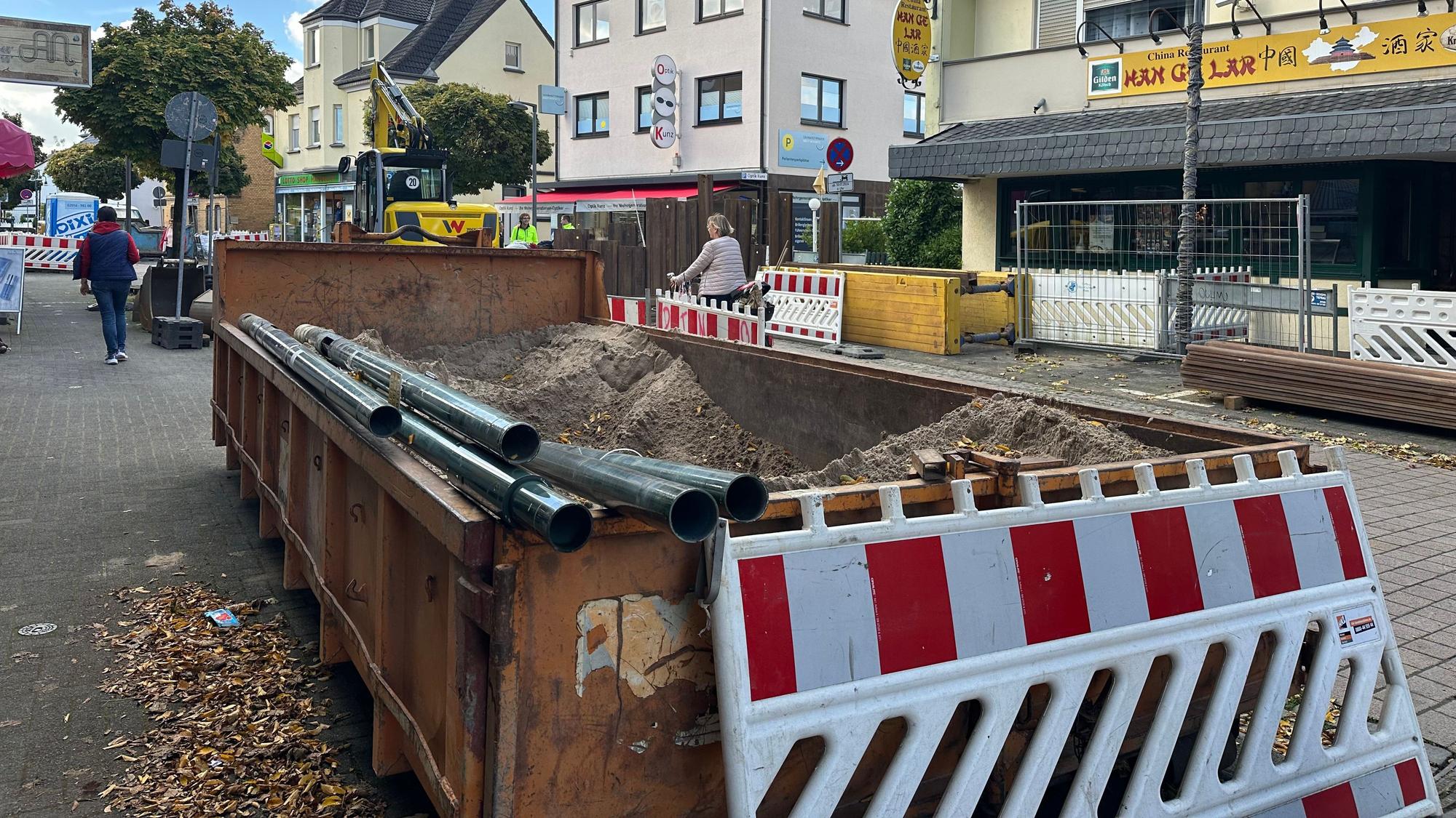 Die Kölnstaße in Hangelar ist im August 2024 durch Tiefbauarbeiten teilweise komplett gesperrt. Baucontainer und Sperrbarken sind überall zu sehen. Fußgänge müssen Slalom gehen.