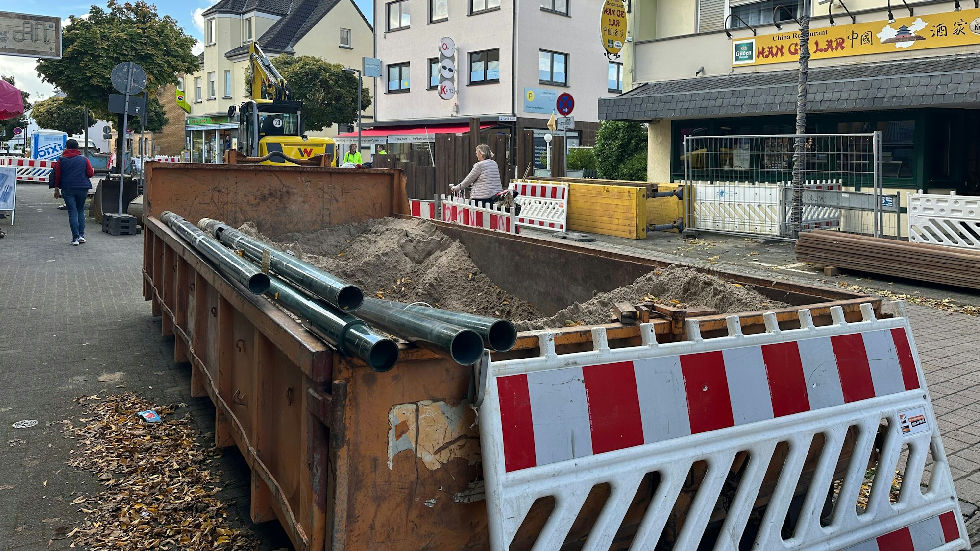 Die Kölnstaße in Hangelar ist im August 2024 durch Tiefbauarbeiten teilweise komplett gesperrt. Baucontainer und Sperrbarken sind überall zu sehen. Fußgänge müssen Slalom gehen.