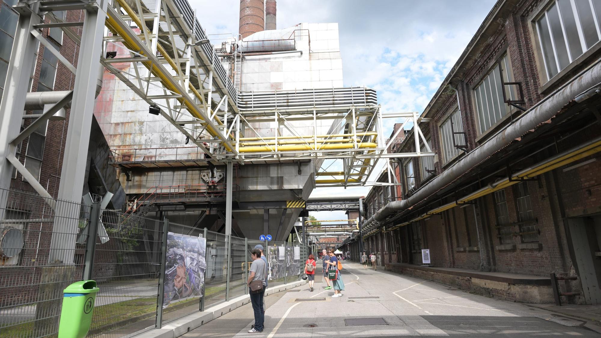 Blick in eine Straße, an der rechts und links Industriehallen stehen.