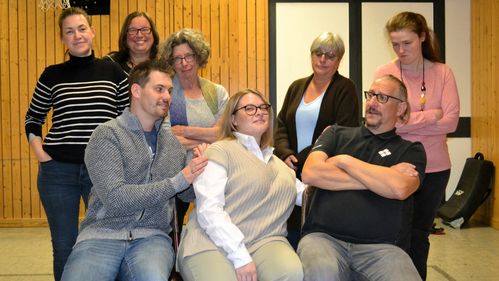 Ein Gruppenfoto mit Männern und Frauen in einer Sporthalle.