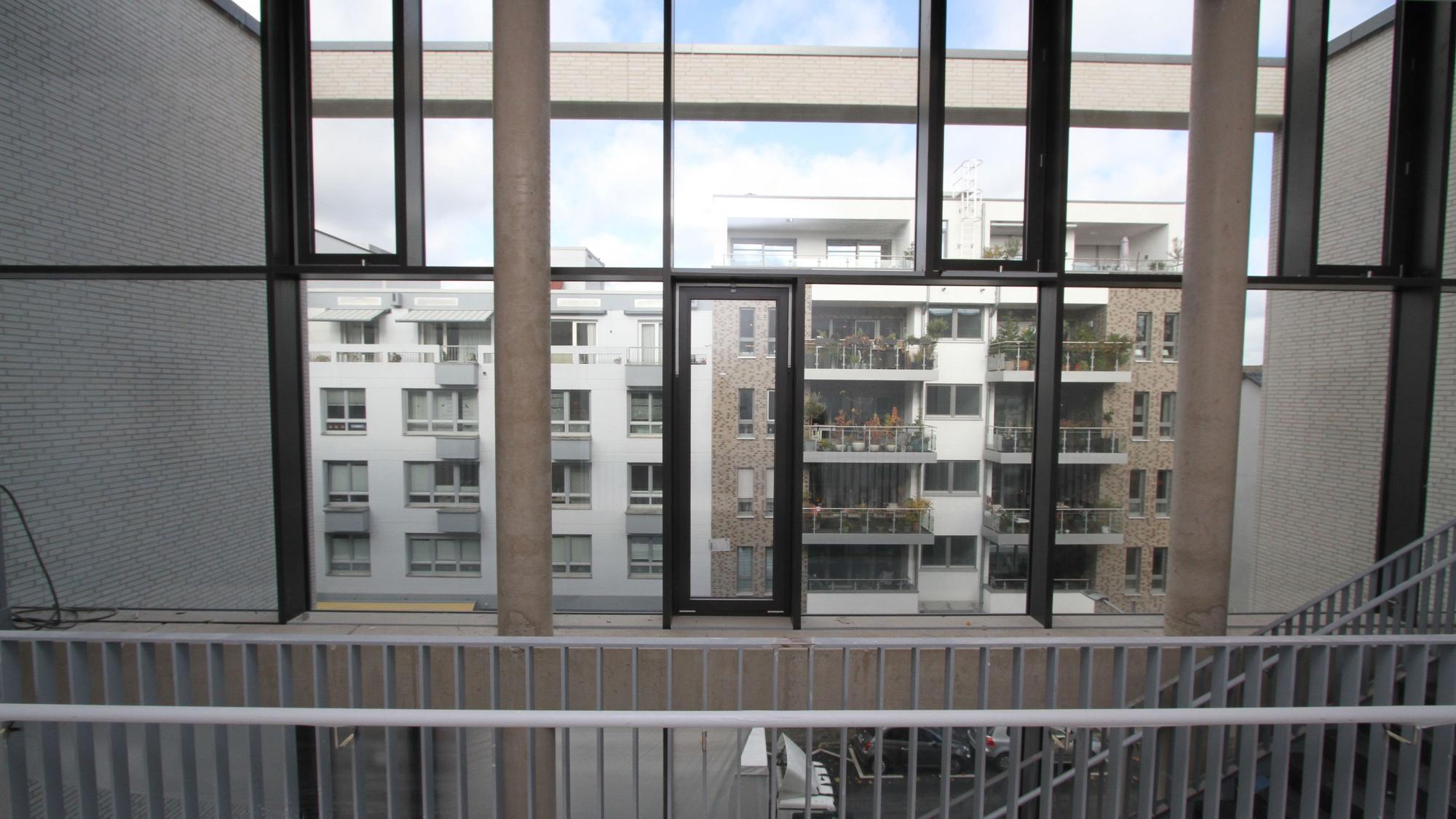 Häuser durch eine untergliederte Fensterfront gesehen.