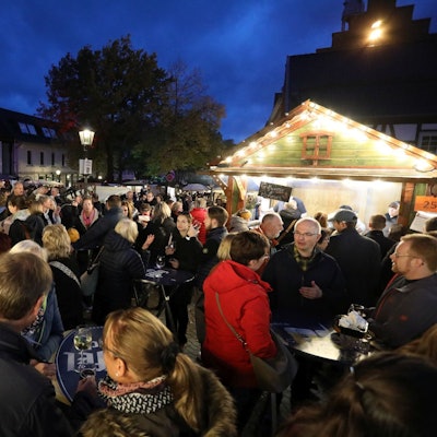 Zahlreiche Menschen stehen eng zusammen an und vor den Buden des Martini Marktes.
