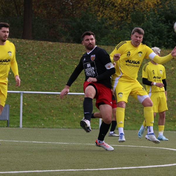 Ein Spieler hat den Ball weggeschossen, ein Gegenspieler bedrängt ihn.
