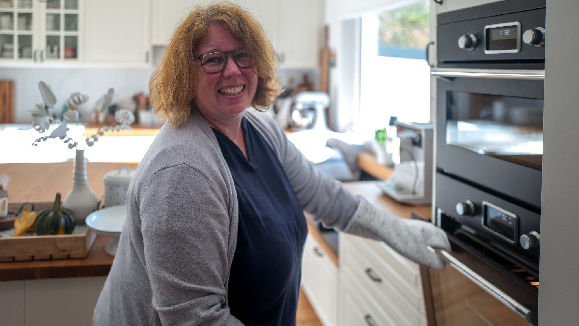 Das Bild zeigt Annette Kleinertz in ihrer Küche. Sie steht am Backofen.