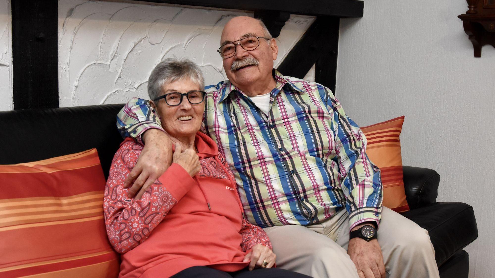 Ein Mann und eine Frau sitzen auf einem Sofa.