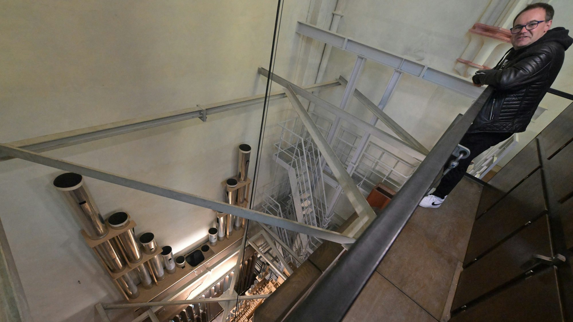 Domorganist Rolf Müller auf der oberen Ebene der Orgel im Altenberger-Dom. Rechts ist die neue Metalltreppe zu sehen, links die Orgelpfeifen.