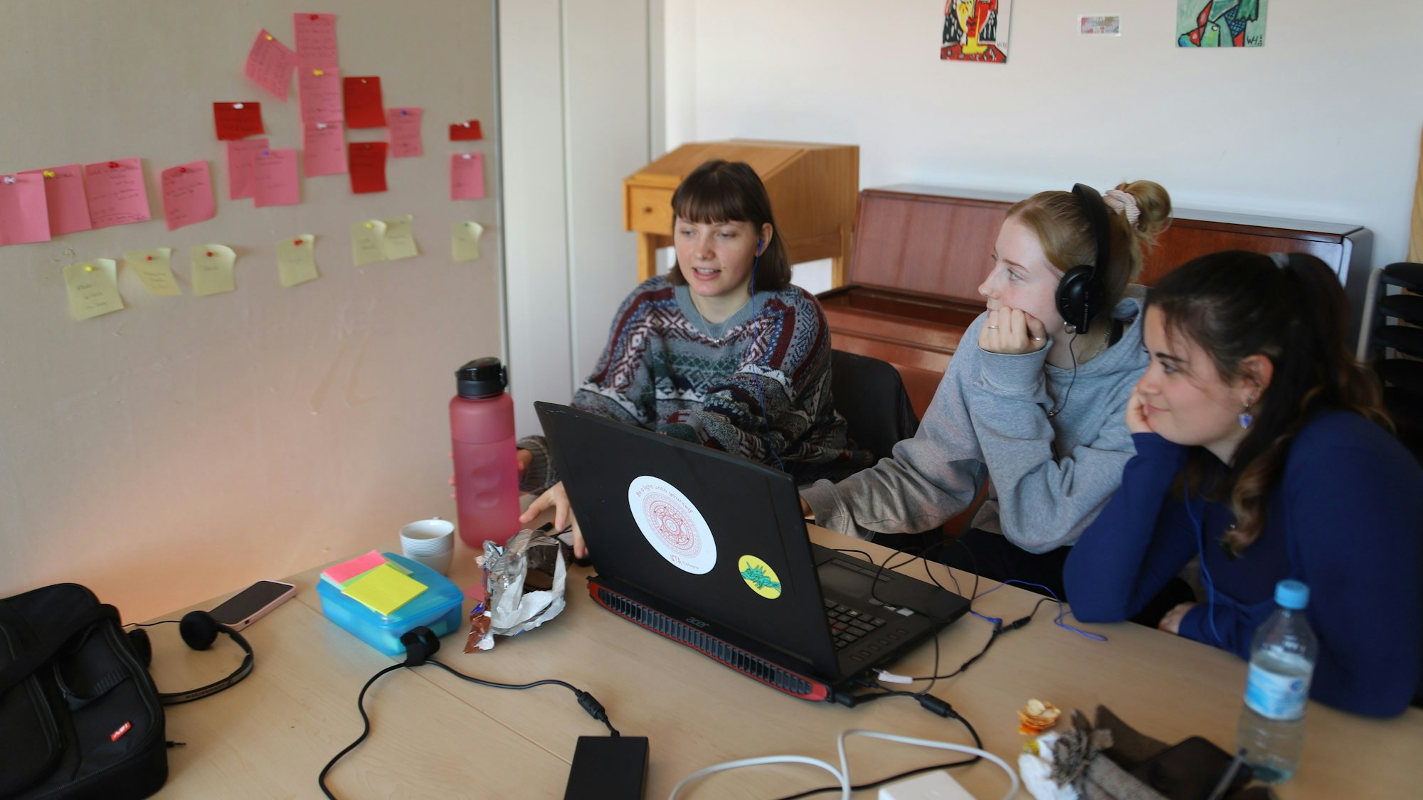 Drei junge Frauen schneiden am Rechner einen Film.