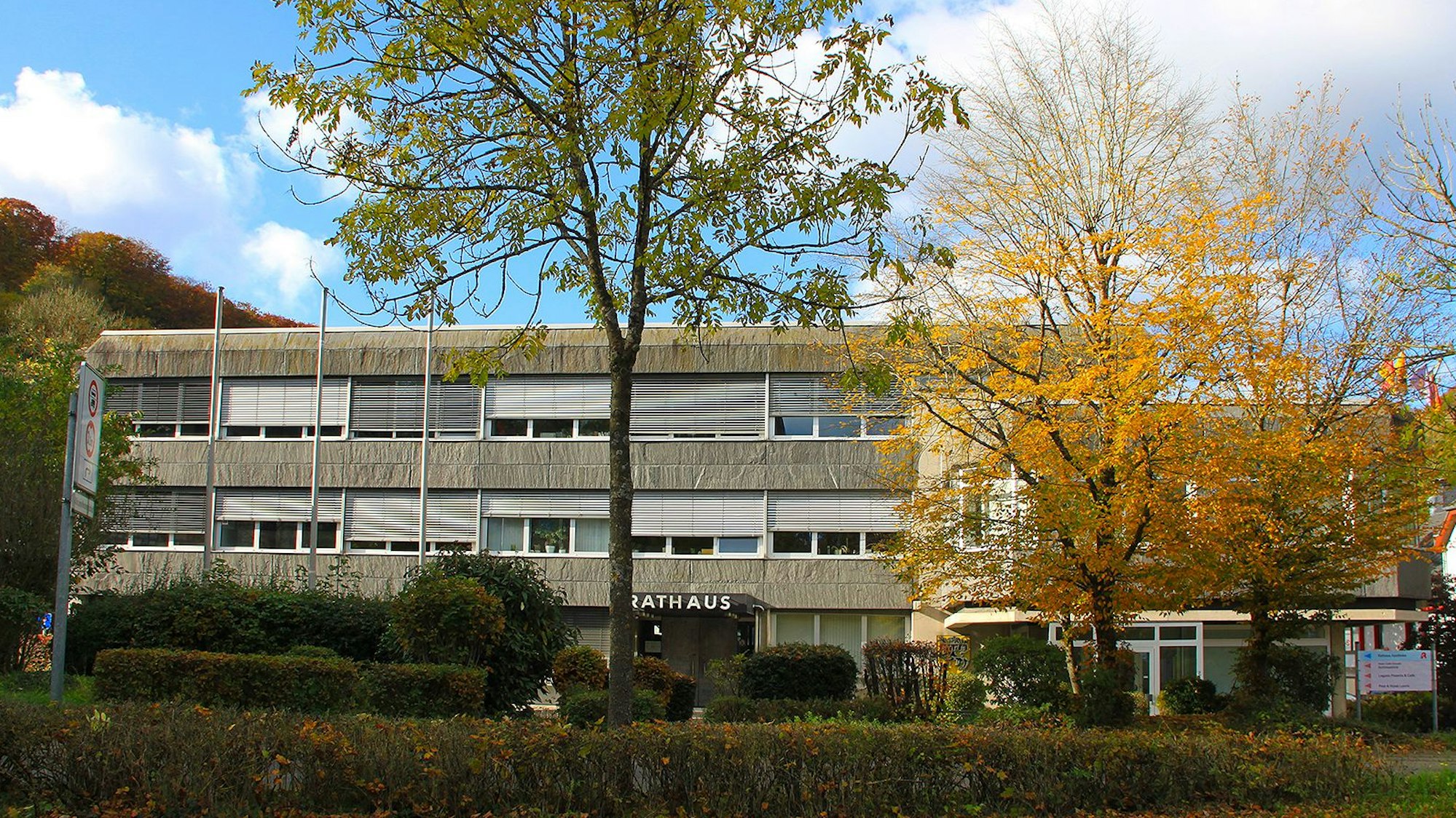 Vor dem Rathaus in Blankenheim stehen mehrere Bäume, deren Blätter herbstlich gefärbt sind.