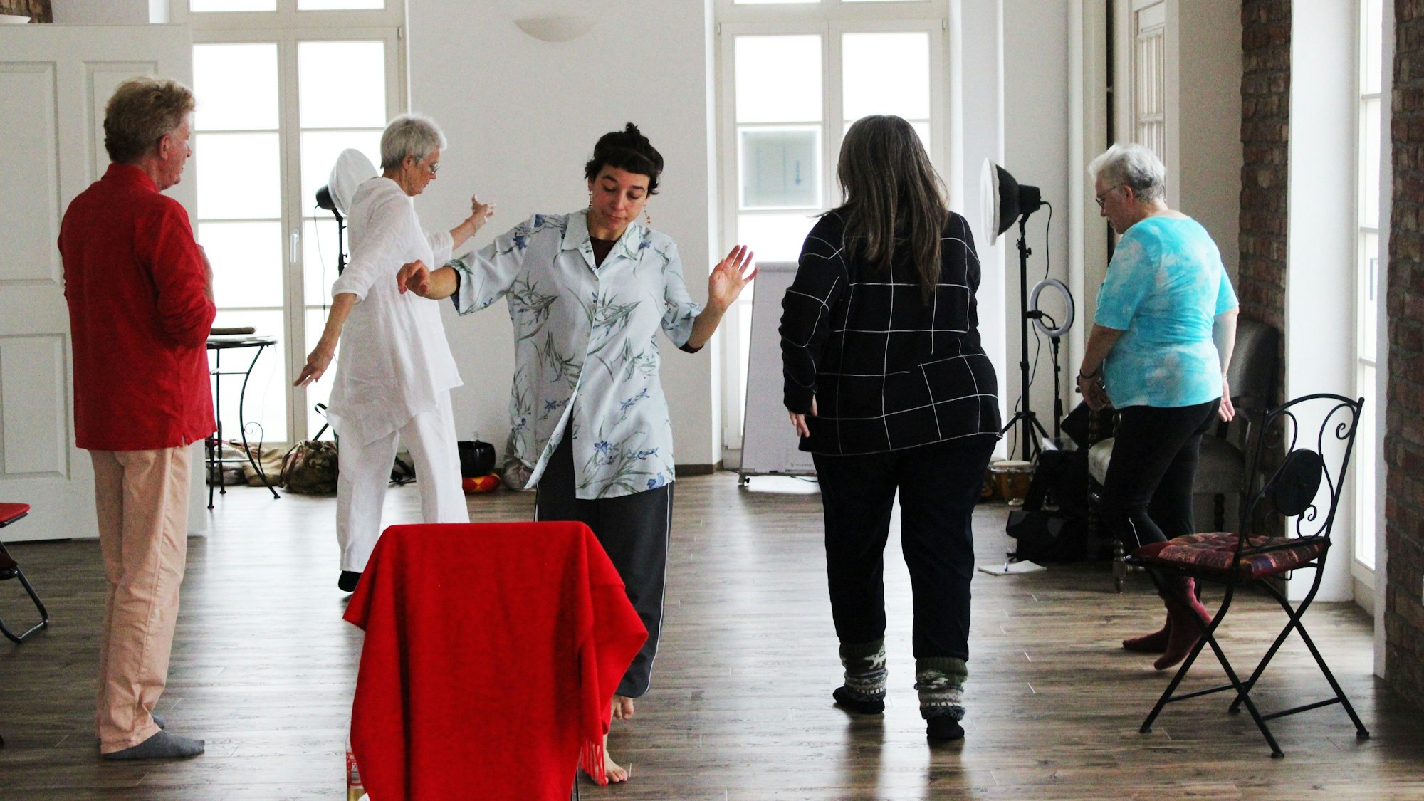 Fünf Menschen tanzen in einem Raum.