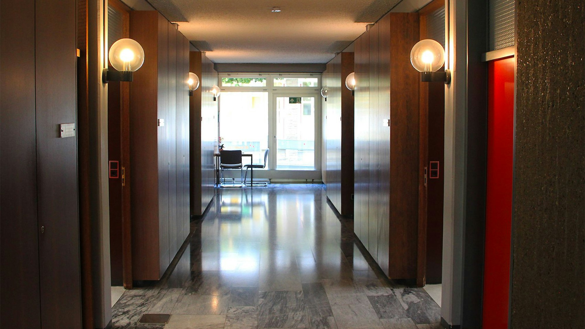 In den Fluren im Blankenheimer Rathaus sind die Wände mit dunklem Holz vertäfelt. Mehrere runde Glaslampen sind eingeschaltet.