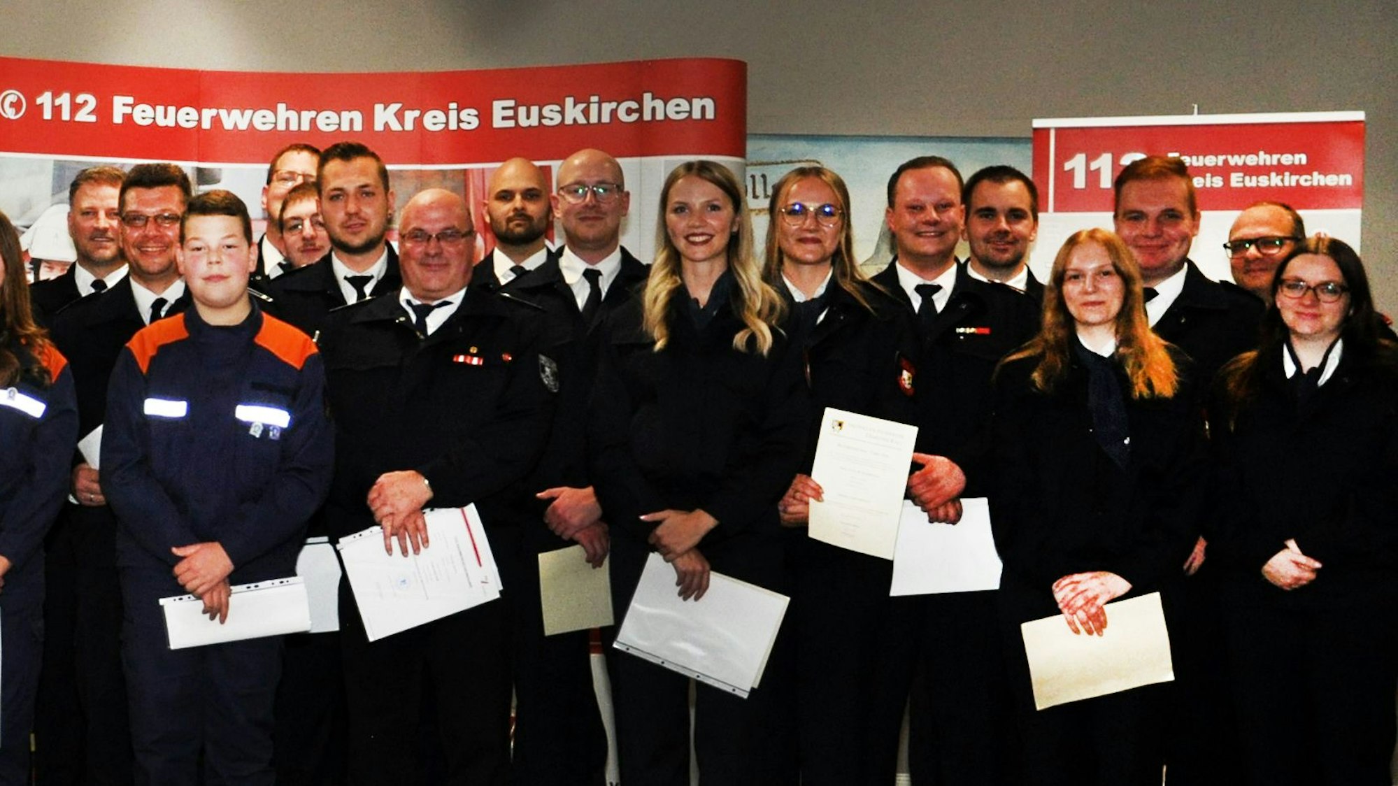 Einsatzkräfte des Löschzugs Kall posieren mit Urkunden für den Fotografen.