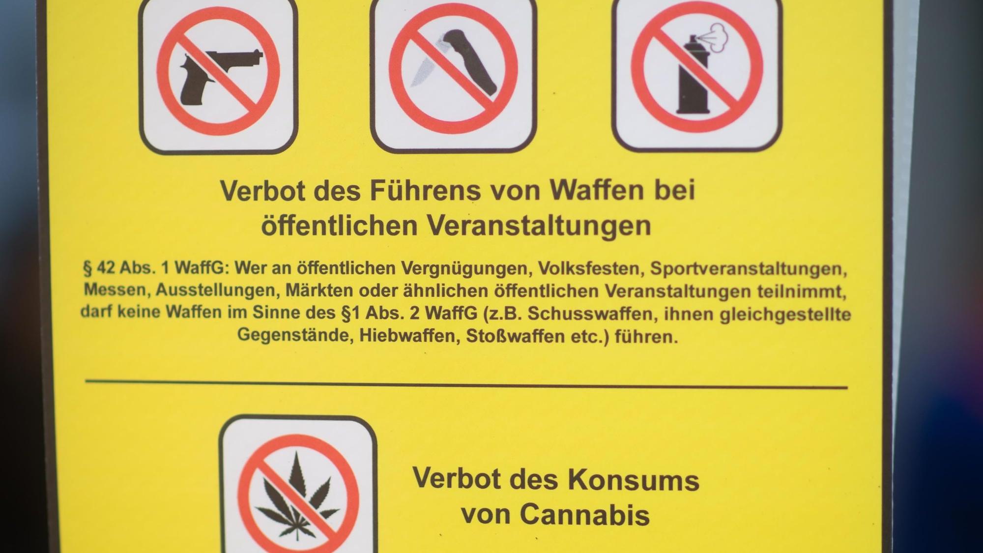 Ein Verbotsschild weist darauf hin, dass keine Waffen zu öffentlichen Veranstaltungen mitgeführt werden dürfen. Auch der Konsum von Cannabis ist in diesem Fall verboten.