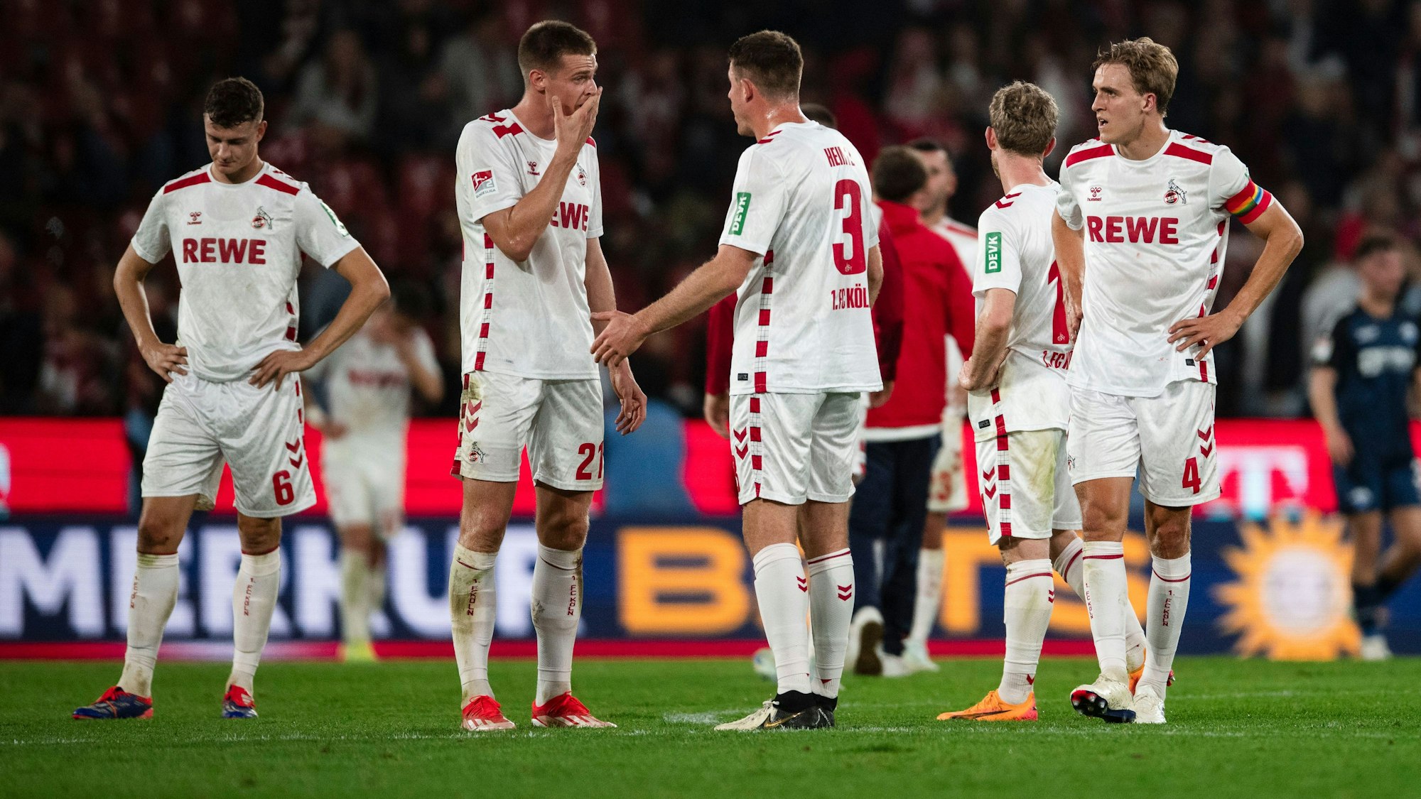 Kölns Eric Martel (l-r), Steffen Tigges, Dominique Heintz und Timo Hübers stehen unzufrieden nach der Partie auf dem Feld.