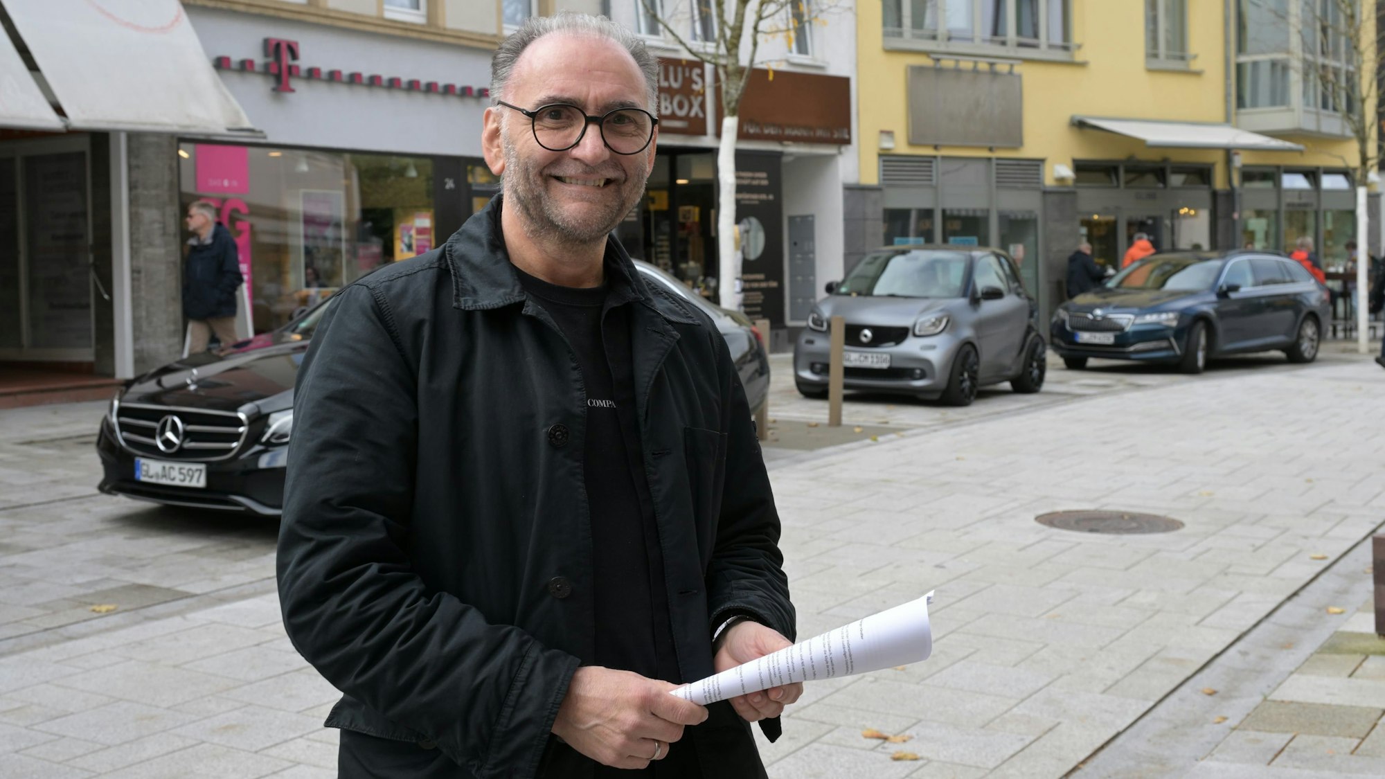 Der Geschäftsmann hält die Unterschriftenliste in der Hand.