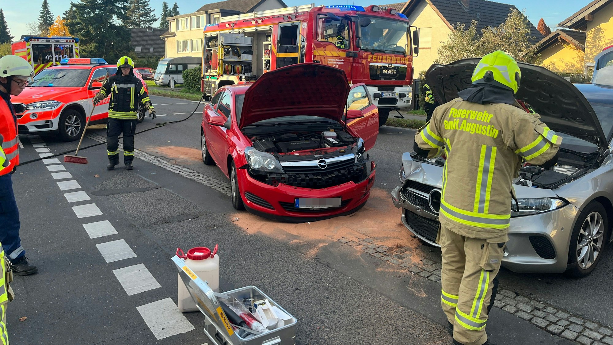 Feuerwehrleute arbeiten an zwei Autos, die zusammengestoßen sind.