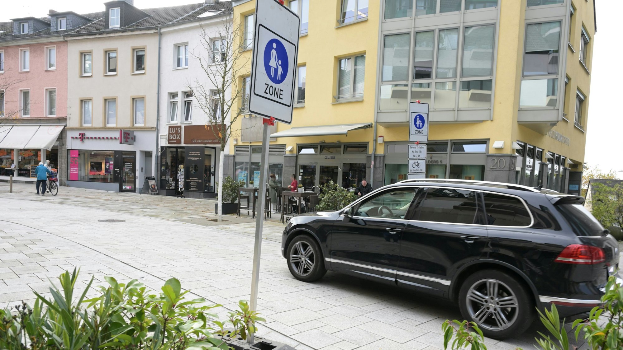 Ein Auto fährt an dem Verkehrsschild Fußgängerzone vorbei.