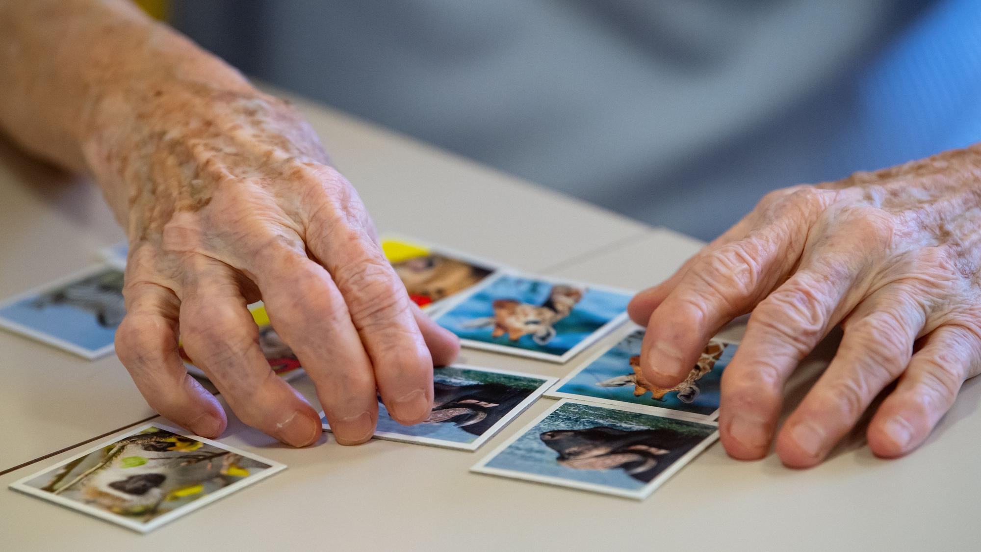 Eine Bewohnerin eines Altenheims spielt auf einer Pflegestation das Spiel „Memory“und legt Kartenpaare zusammen.