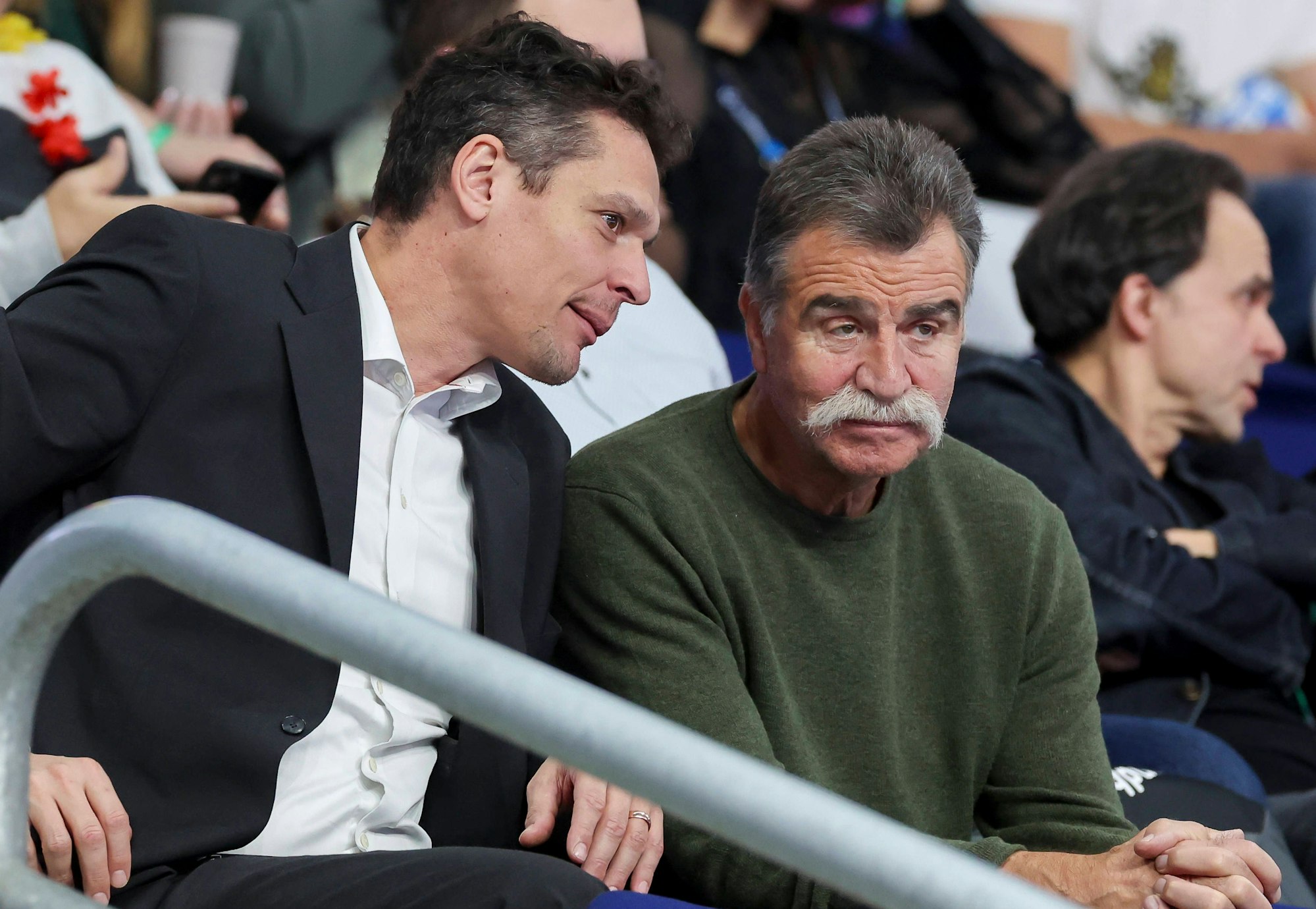 Frank von Behren und Heiner Brand sitzen auf der Tribüne,