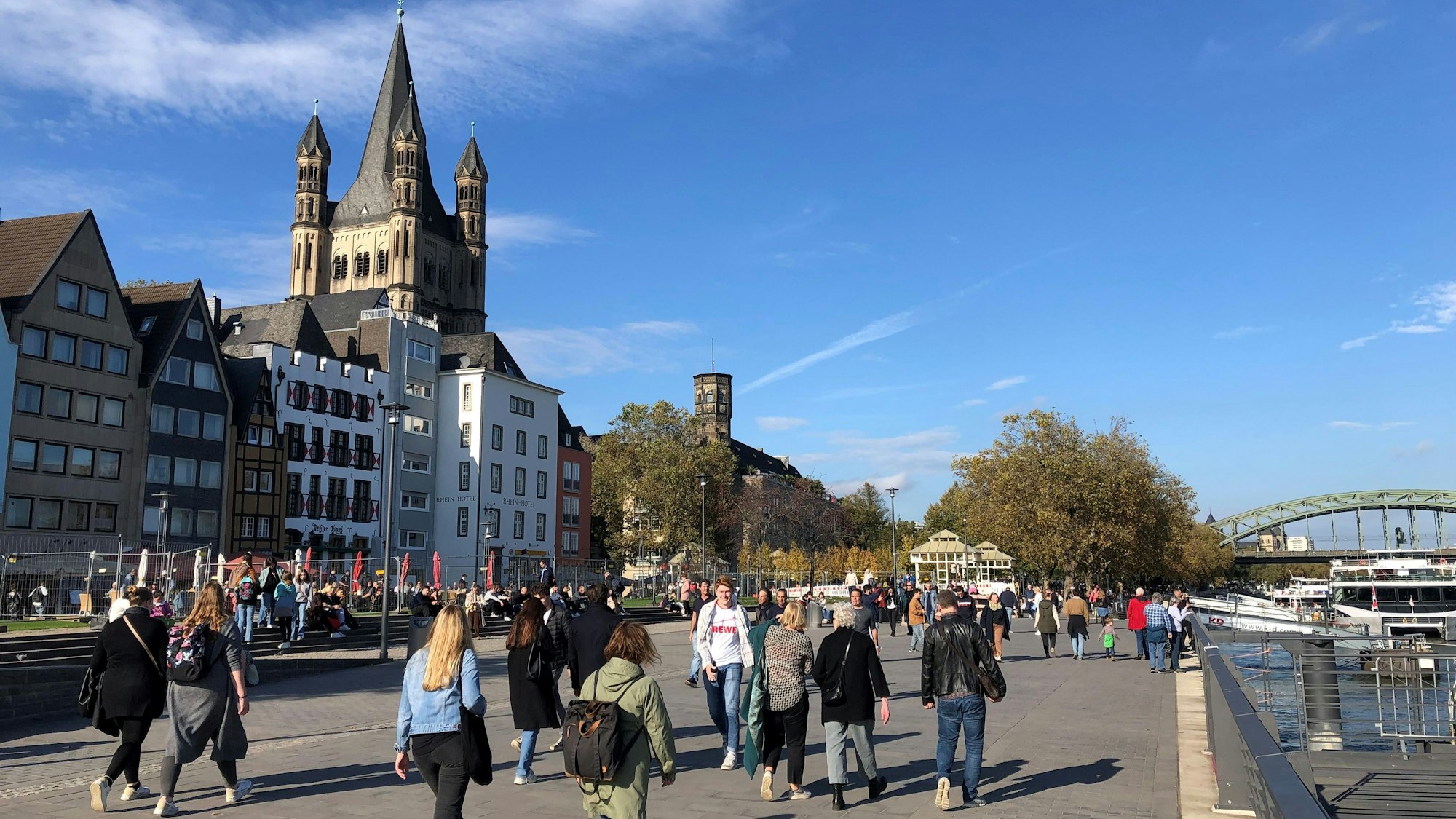 Spaziergänger genießen bei einem Bummel über die frisch fertiggestellte Kragplatte am Kölner Altstadtufer den Sonnenschein.