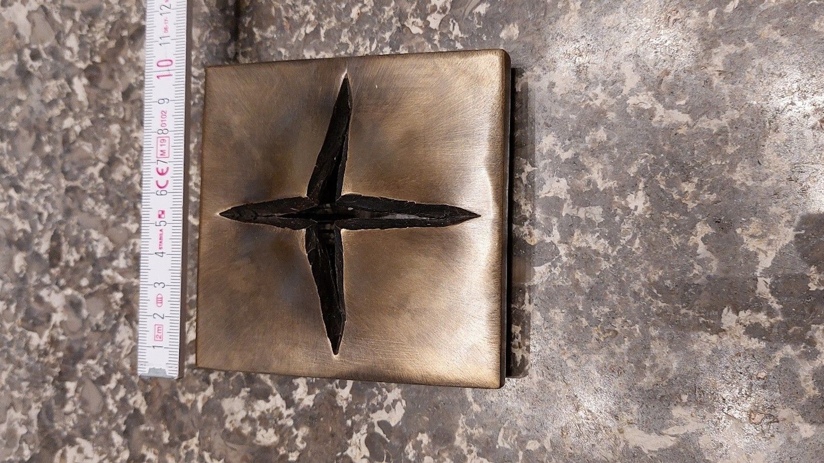 Das gestohlene, moderne Kreuz aus Bronze: Eine Metallplatte, die in Form eines Kreuzes aufreißt.