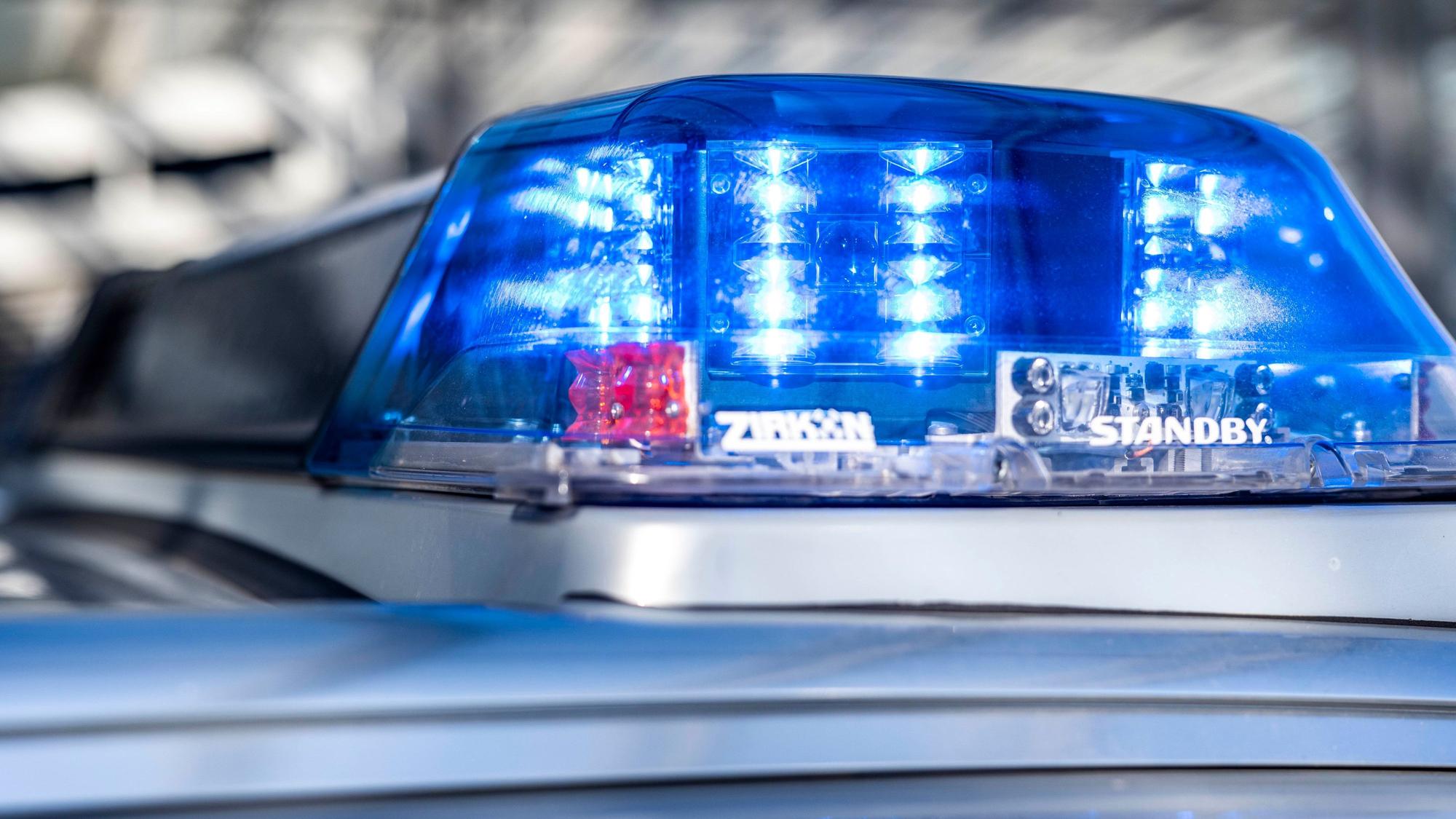 Das Blaulicht an einem Polizeiwagen ist eingeschaltet.