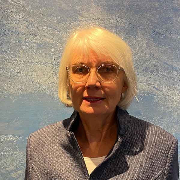 Die Preisträgerin, sie hat weiße Haare, die ihr bis zum Kinn reichen und trägt eine transparente Brille.