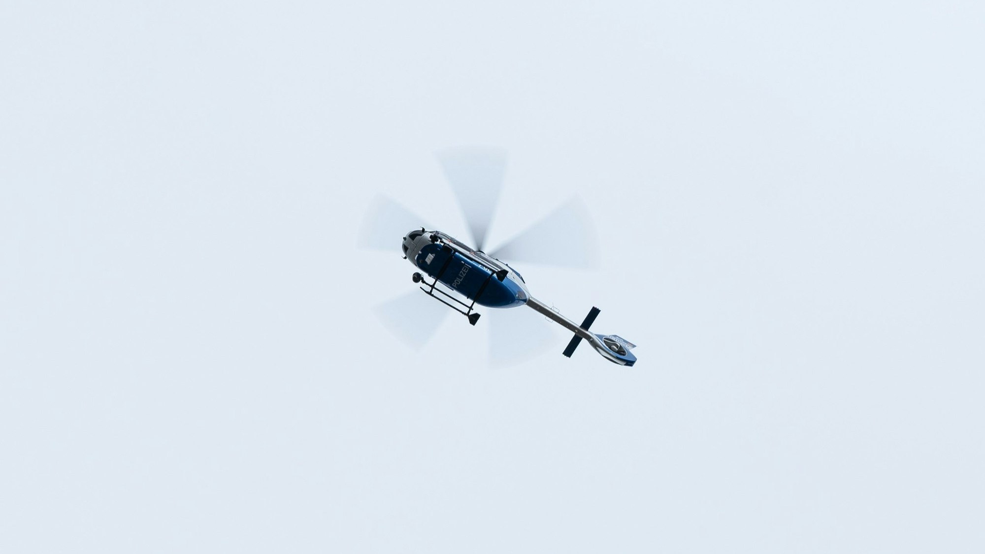 ARCHIV - 14.01.2023, Baden-Württemberg, Freiburg im Breisgau: Ein Polizeihubschrauber fliegt vor Beginn einer Entschärfung einer Fliegerbombe über das Evakuierte Gelände. In der Nähe der Freiburger Uniklinik war am Mittwoch eine 500-Kilo-Fliegerbombe aus dem Zweiten Weltkrieg gefunden worden. (zu dpa: «Banküberfall in Winnenden - Fahndung nach Täter») Foto: Silas Stein/dpa +++ dpa-Bildfunk +++